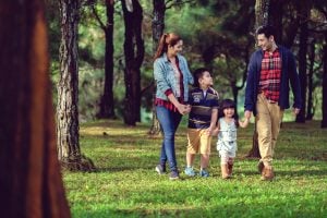 A Filipino family of four having a peaceful walk around the lush sceneries set by the vast number of pine trees in Crosswinds Tagaytay | Luxury Homes by Brittany Corporation