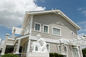 Statues of angels in front of a gray Old American-themed luxury house at Georgia Club | Brittany Sta. Rosa | Luxury Homes by Brittany Corporation