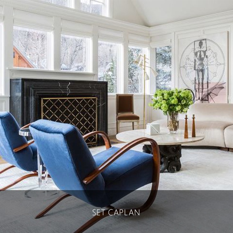 two blue chairs in front of a fire place and marble table with a painting of a skeleton in a luxury house | Luxury homes by brittany corporation 