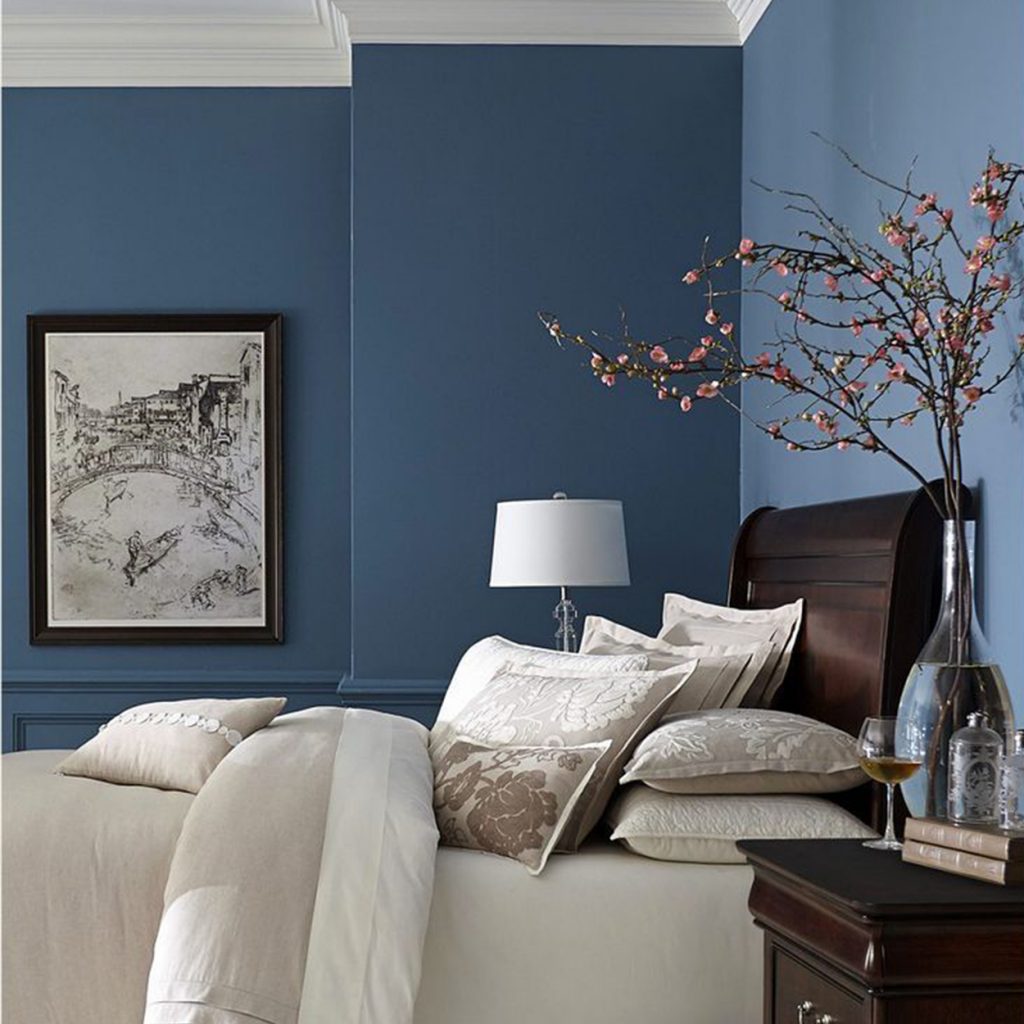 navy blue walls with a framed drawing white bed in a luxury mansion with a sakura plant on the end table | luxury homes by brittany corporation