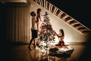 A young white family of three decorating their small Christmas tree in their luxury house | Luxury Homes by Brittany Corporation