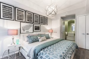 Low wide angle shot of a small bedroom with unique and colorful patterns on the wall, the rug, and the bedsheets | Luxury Homes by Brittany Corporation