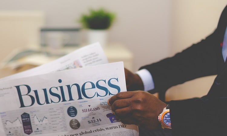 Man reading about Filipino-Owned Businesses in the the Business section of the newspaper | Luxury Homes by Brittany Corporation