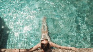 Girl swimming in a luxury pool in her luxury home | Luxury homes by Brittany Corporation