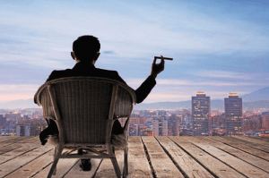 Wealth man sitting on the roof of his luxury home looking at the city - Luxury homes by Brittany