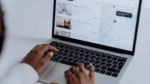 back view of a girl looking through property listing by geographic location using her laptop