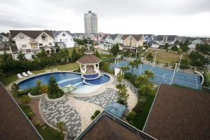 Wide area shot of a San Franciscan inspired village with a basketball court and clubhouse with swimming pool, all in pastel colors | Luxury Homes by Brittany Corporation