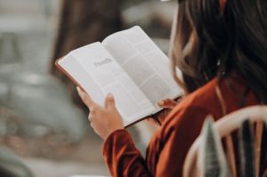 Girl reading a novel as an indoor activity on a chair in the patio and staying at home in her luxury house and lot | Luxury Homes by Brittany Corporation