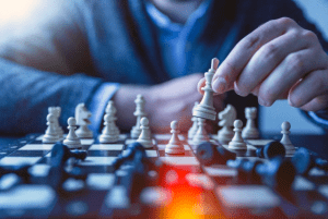 Man playing chess as an indoor activity in his luxury home - Luxury homes by Brittany Corporation