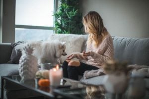 Woman feeding her dog in the living room of her luxury home at Brittany as a way to practicing self-care