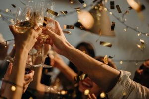 A group of young people celebrating a birthday by raising a toast with champagne | Luxury Homes by Brittany Corporation