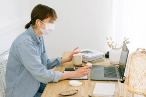 Woman using her laptop on a Zoom call celebrating her friend's birthday | Luxury Homes by Brittany Corporation