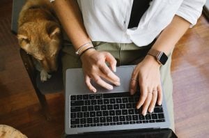 A woman working remotely at home in her own space with her pet Shiba Inu | Luxury Homes by Brittany Corporation