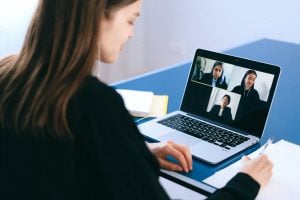 A young professional woman on her laptop in her luxury home in a meeting on Zoom showing the digital transformation of the workplace | Luxury Homes by Brittany Corporation