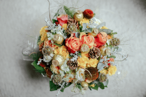 Top view of colorful flower arrangement with roses, twigs, pinecones, and ornaments | Luxury Homes by Brittany Corporation