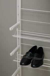 Black leather loafers with silver chain accent, displayed on a white shoe rack | Luxury Homes by Brittany Corporation