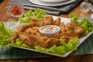 Chicken tenders, cooked in an air fryer which is one of the trendy new home items, on a bed of lettuce, with ranch dressing | Luxury Homes by Brittany Corporation