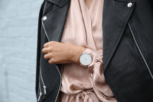 Leather jacket on silky rose gold dress and rose gold watch worn by an olive skin girl for power dressing in her workplace | Luxury Homes by Brittany Corporation