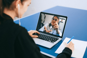 Woman having an online webcam meeting with an old lady, while taking down notes | Luxury Homes by Brittany Corporation