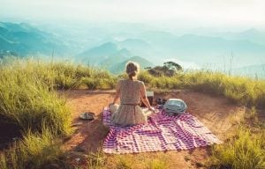 woman sitting on top of a hill with table cloth and picnic basket in Swiss-inspired luxury village in Tagaytay | Luxury Homes by Brittany Corporation