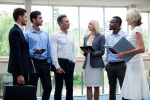 Business executives interacting with each other in a conference center lobby | Luxury Homes by Brittany Corporation