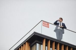 Young real estate professional taking a call on the balcony of a luxury house and lot for sale in the Philippines | Luxury Homes by Brittany Corporation