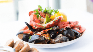 A fresh bowl of seafood marinara served on a white platter | Luxury Homes by Brittany Corporation