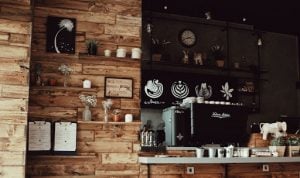 Coffee station in luxury home featuring wooden plank walls espresso machine and different kinds of coffee | Luxury Homes by Brittany Corporation