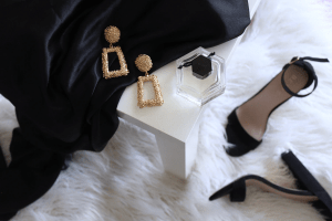 Stiletto heels and luxury jewelry on a white fur carpet in a luxury home by Brittany Corporation