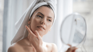 Woman checking out her facial features for skincare in the bathroom | luxury lifestyle and home by Brittany Corporation