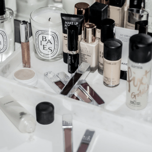 An array of various makeup items on a white marble table