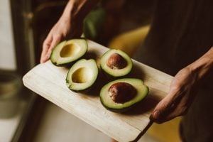 Avocado sliced into two with seeds intact in a kitchen in a luxury home | luxury homes by brittany corporation