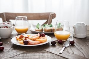 Breakfast table of fruits vegetables bread and fruit juices condo living guide | Luxury Homes by Brittany Corporation