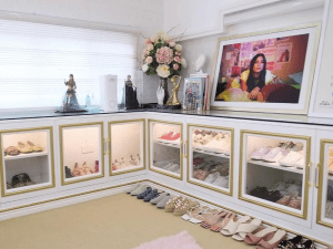 Chic and girlywhite and pink walk in closet with flowers and framed photo.