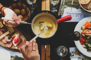 Friends sharing a cheese dip for their potatoes condo living guide | Luxury Homes by Brittany Corporation