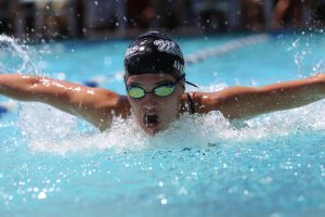 Man doing butterfly strokes in olympic pool | Luxury Homes by Brittany Corporation