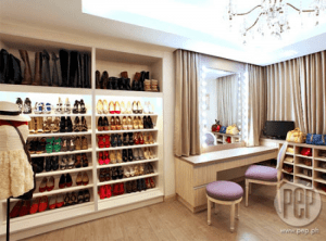 Modern and elegant walk in closet in neutral colors with vanity.