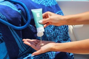 Pouring sunscreen before heading outside condo living guide | Luxury Homes by Brittany Corporation