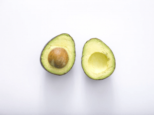 sliced avocado on clean white marble table | luxury lifestyle and homes by brittany corporation