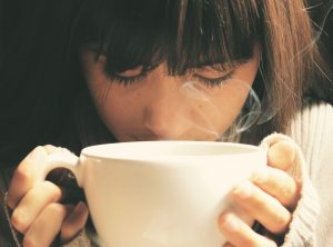 Woman smelling her coffee at the comfort of her own luxury home | luxury homes by brittany corporation