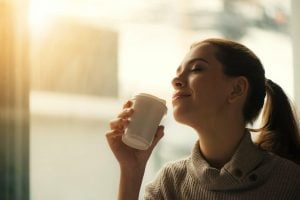 Woman smelling tea inside her luxury house and lot | Luxury properties by Brittany Corporation