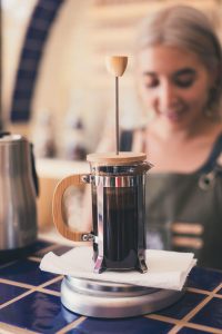 A french press on top of a blue countertop inside a luxury home | Luxury homes by brittany corporation