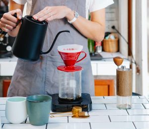 Woman making pour over tea in her luxury condominium | Luxury Homes by brittany corporation