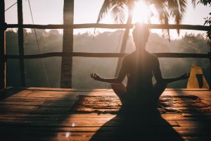 silhouette of girl meditating and doing a yoga pose in an island | luxury lifestyle and homes by brittany corporation