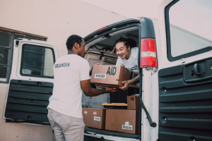 asian and black male humanitarians wearing volunteer shirts to donate to the needy | luxury homes by brittany corporation