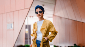 Woman in yellow trench coat with sunglasses and confidently flaunting her style tips - Brittany Corporation