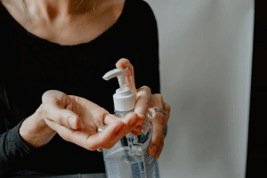 woman applying hand sanitizer or alcohol against covid virus during pandemic | luxury homes by brittany corporation