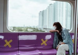 Woman sitting in a train overlooking a luxury condominium | Luxury Homes by Brittany Corporation