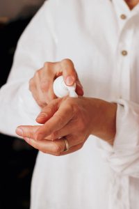 woman in white clean linen shirt wearing sunblock in the house | luxury homes by brittany corporation