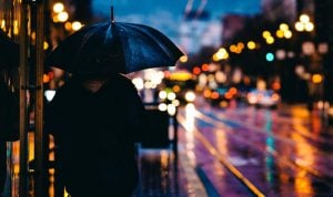 person with umbrella showing city lights at night | luxury homes by brittany corporation